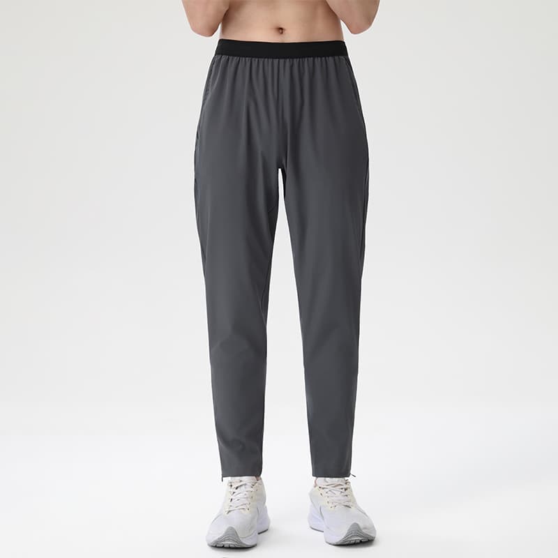 Male model wearing Tensuit dark grey lightweight running pants front view