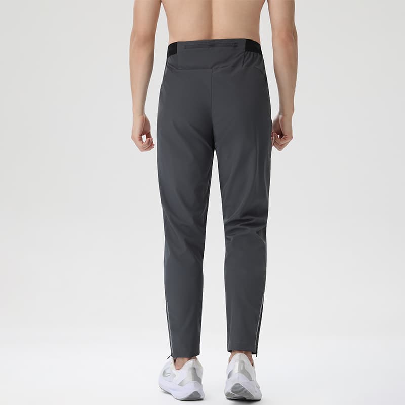 Male model wearing Tensuit dark grey lightweight running pants back view