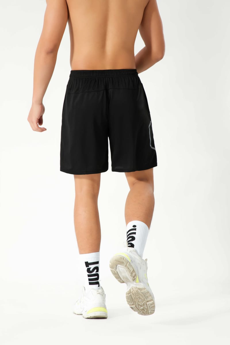 Male model wearing Tensuit black polyester athletic sports shorts back view with reflective strip